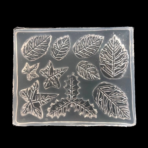 Macro shot of 9 mixed leaf patterns on a transparent silicone mold for DIY resin art