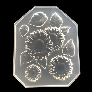 Détail macro du moule en silicone translucide avec motifs de tournesols et feuilles
