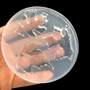Translucent silicone leaf mold for DIY resin jewelry making on a black background