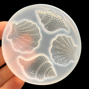 Translucent round silicone mold with four detailed seashell and conch shapes for DIY resin