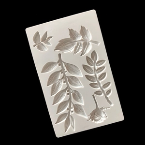 White silicone mold featuring detailed rose and leaf vine patterns for cake decorating