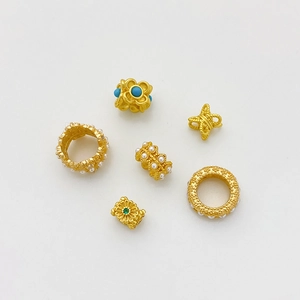 Detalle de cuentas doradas vintage con perlas y turquesa para creación de joyería DIY
