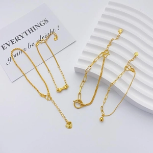 Macro detail of 24K gold plated adjustable bracelets with heart and bow charms