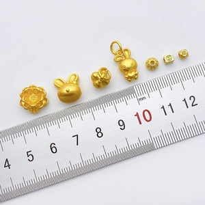 DIY gold-plated rabbit and flower jewelry charms for bracelets shown on a ruler