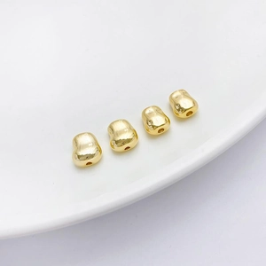 Detalle macro de cuatro cuentas bañadas en oro 14K con forma de corazón para joyas DIY