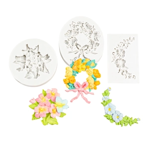 Trois moules en silicone détaillés avec décorations de fleurs en fondant et savon