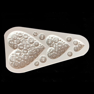 Macro detail of white silicone mold featuring diverse button textures for fondant and clay
