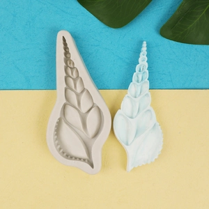 Macro shot of a spiral seashell silicone mold and a white fondant cast for DIY baking cake decor