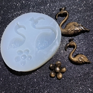 Detailed view of flamingo silicone mold with finished golden swan resin ornaments