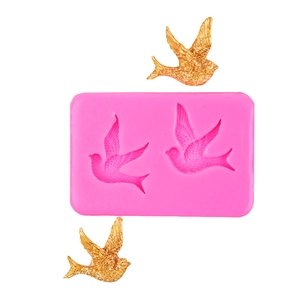 Detail of pink silicone bird mold with bird-shaped gold fondant showing feather textures