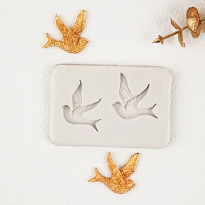 Detailed white silicone mold featuring dual swallow shapes for cake decorating and fondant