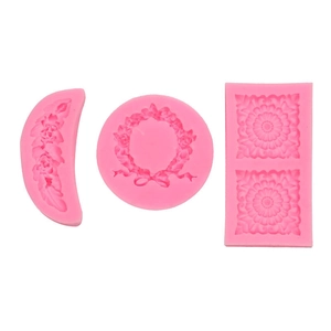 Macro shot of pink silicone resin molds with detailed floral and wreath patterns