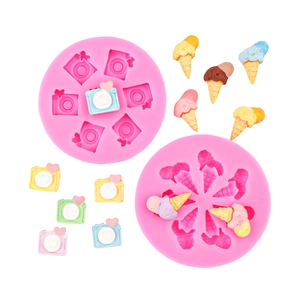 Pink silicone camera and ice cream molds with colorful handmade crafts on white background