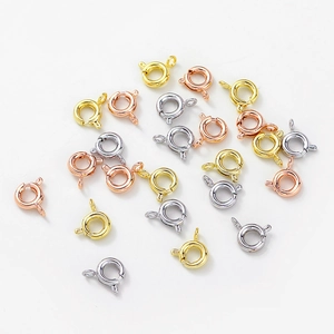 Detailed view of mixed gold, rose gold, and silver spring ring clasps for jewelry making