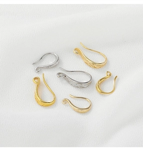 Detailed macro view of 14K gold filled ear hooks with intricate engraved textures