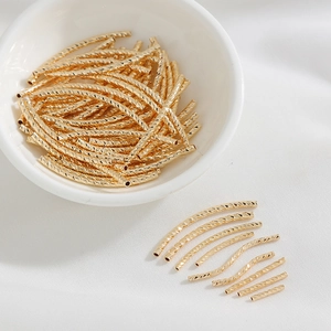Dettaglio di perline a tubo curvo sfaccettate in oro 14K per creazione gioielli DIY