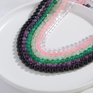 Nahaufnahme bunter Naturachat-Rundperlen für DIY-Schmuck in einer weißen Keramikschale