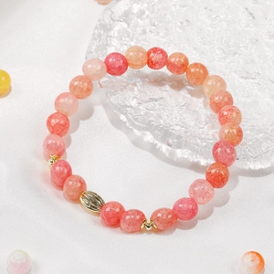 8mm pink crackle quartz beads bracelet with gold accents on textured glass tray
