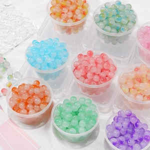 Primer plano de cuentas de vidrio mate de colores para joyería DIY en envases