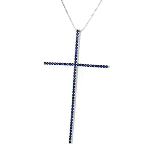 Macro shot of silver cross pendant featuring pave set blue zircon round stones