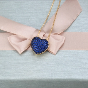 Makroaufnahme von Herzanhänger mit blauen Zirkonia an einer 18k vergoldeten Kette
