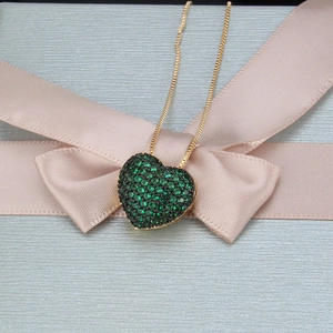Detailansicht des herzförmigen grünen Zirkonia-Anhängers an Goldkette in Geschenkbox