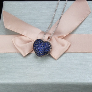 Detailansicht der Herz-Halskette mit blauen Zirkonia-Steinen auf einer eleganten Geschenkbox