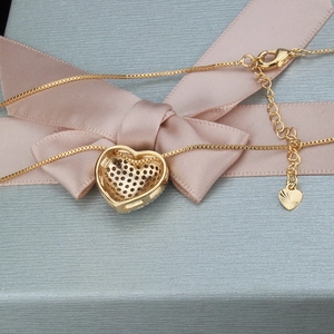 Detail der 18k Gold-Herzanhänger mit Zirkonia-Pflaster auf blauer Geschenkbox