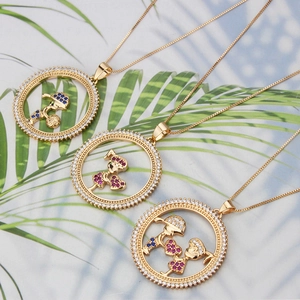 Close-up of 18k gold plated round pendants with diamond inlay and cartoon child motifs