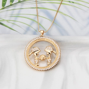 Detailed close-up of 18k gold plated round pendant with pavé crystals and child figures