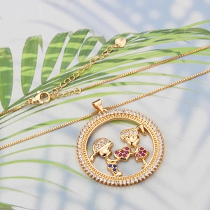 Macro shot of 18k gold plated necklace with hollow boy and girl heart pendant detail