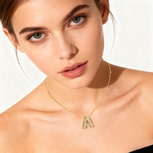 Gold plated balloon letter A necklace with micro-pave cubic zirconia worn by a model