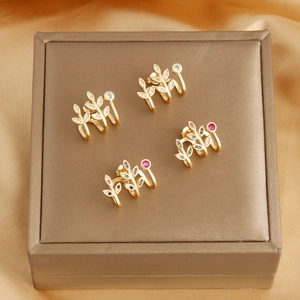 Detailed macro view of 18k gold-plated leaf ear cuffs with sparkling colorful zircons
