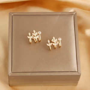 Detailed macro view of 18k gold plated leaf stud earrings with shimmering pave zircon stones