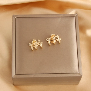 Detail of 18k gold leaf-shaped stud earrings in a luxury gift box on silk