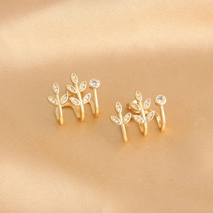 Detailed close-up of 18k gold plated leaf stud earrings with sparkling white zircons