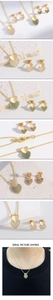Detail of 18k gold heart necklace and earrings set with green and white cubic zirconia