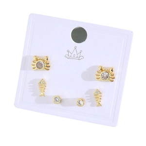 Three pairs of gold crab, fishbone, and zircon stud earrings set on white display card