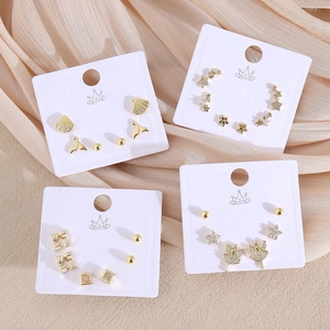 Élégant ensemble de boucles d'oreilles dorées avec zircons sur soie douce