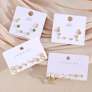 Trois paires de boucles d'oreilles dorées élégantes en forme de cœur sur une carte