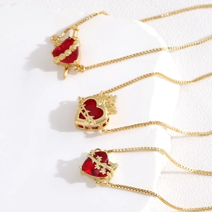 Gothic gold necklace set with red heart gems featuring dagger, thorn, and flame designs