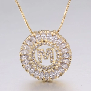 Dettaglio di un ciondolo con lettera M placcato oro 18k con zirconi a marquise scintillanti