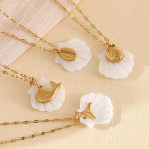 Close-up of gold starfish and seashell pendants with mother of pearl on fine chain