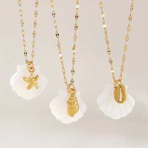 Gold stainless steel ocean necklaces with shell, starfish and conch charms on white background