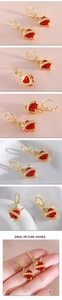 Detailansichten gotischer Herzohrringe mit roten Edelsteinen und goldenen Rosen