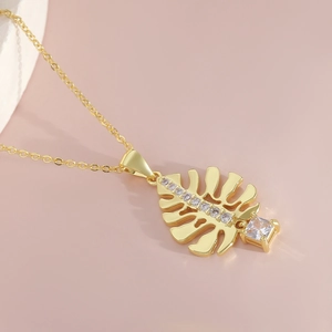 Elegante collana a foglia dorata con pavé di zirconi su uno sfondo rosa delicato