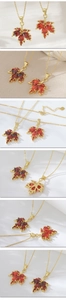 Détails macro du pendentif feuille d'érable avec zircons rouges et dorure