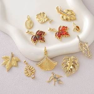 Assorted 18k gold plated maple and ginkgo leaf pendants with sparkling red cubic zirconia