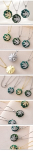Macro detail of enamel lotus leaf and zircon paved frog pendant necklace in gold and silver