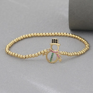 Detalle de pulsera de oro 18k con colgante de muñeco de nieve y circonitas de colores